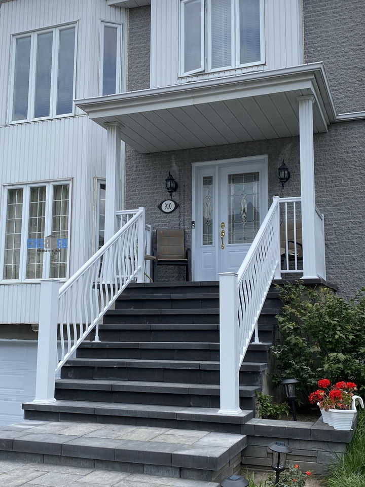 Escalier d'entrée avec rampes blanches devant un duplex