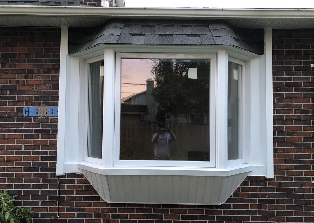Fenêtre en baie blanche sur une maison de brique